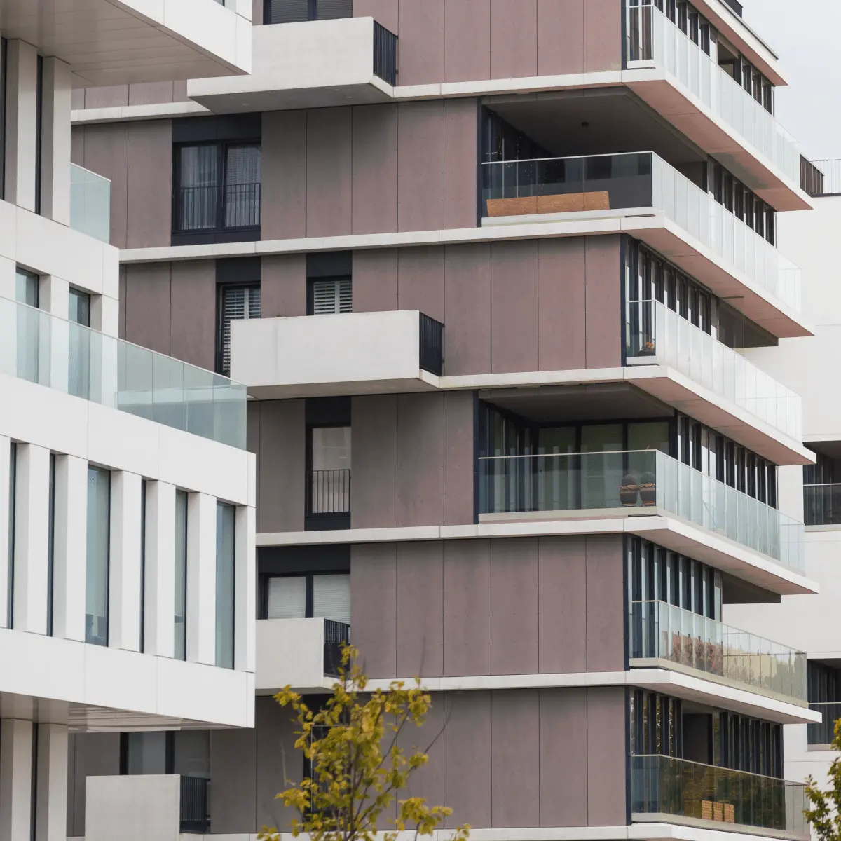 Modernes mehrstöckiges Wohngebäude mit Balkonen und heller Fassade.