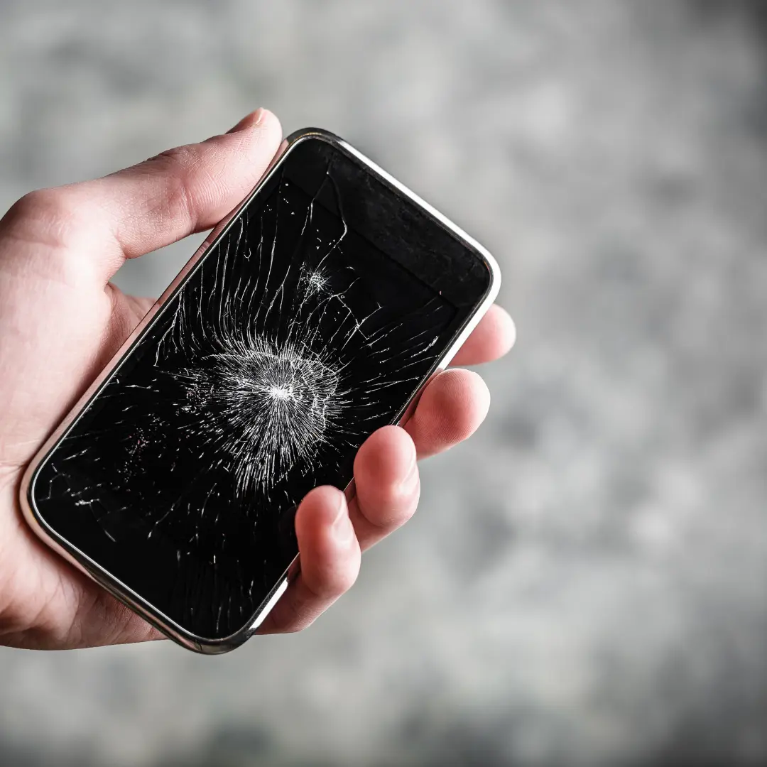 Nahaufnahme eines Smartphones mit deutlich gesprungenem und beschädigtem Display.